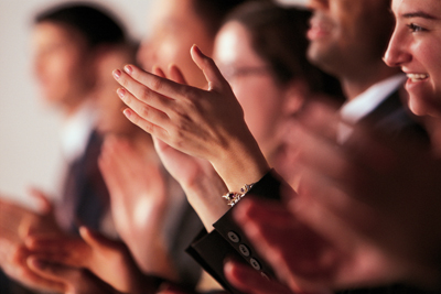 A picture of an audience clapping.