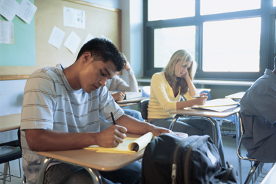 A picture of several students in school writing.