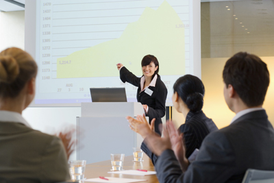 A picture of a woman giving a presentation.